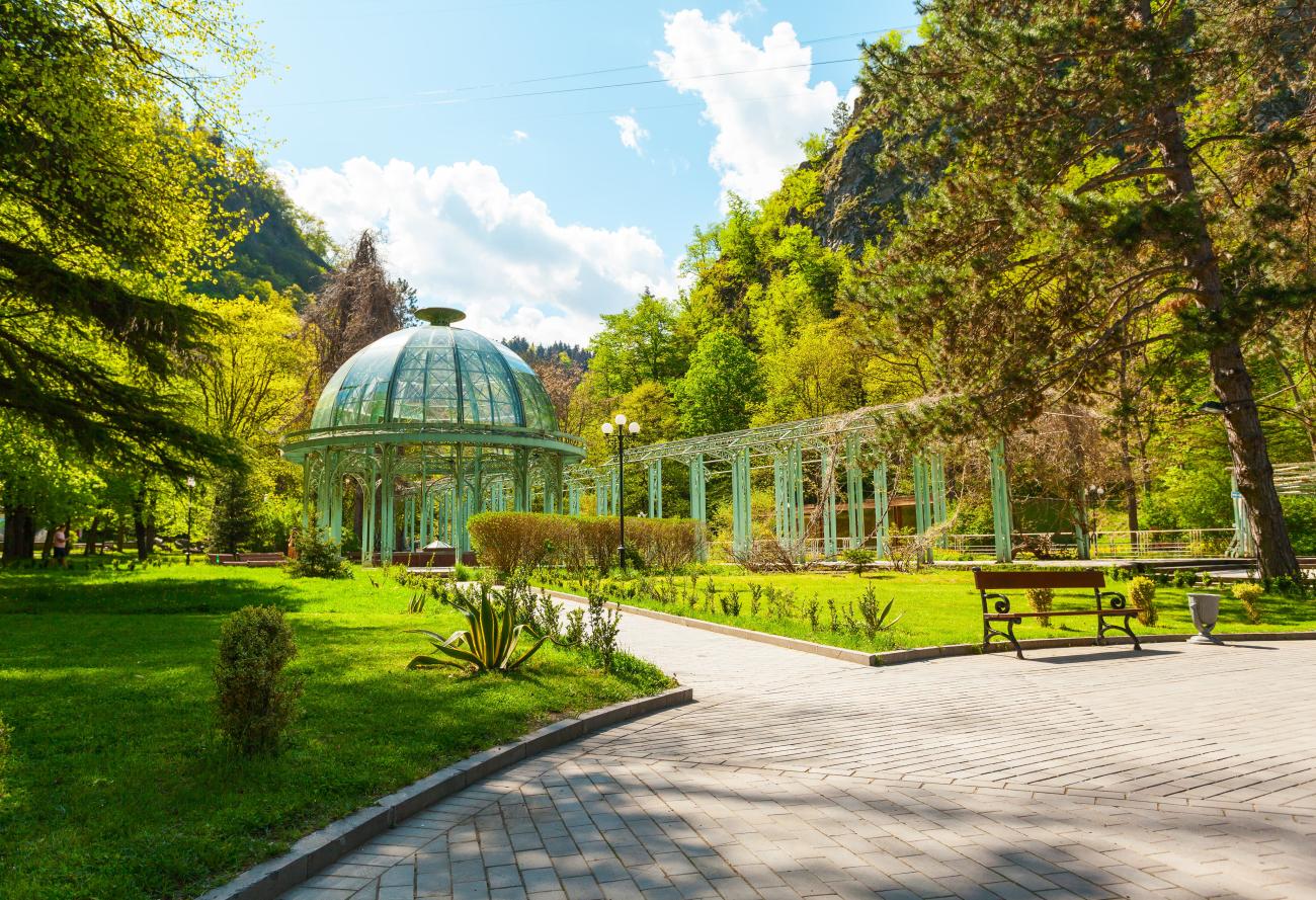 Glass pavilion in Borjomi National Park, Georgia with surrounding trees and walkway